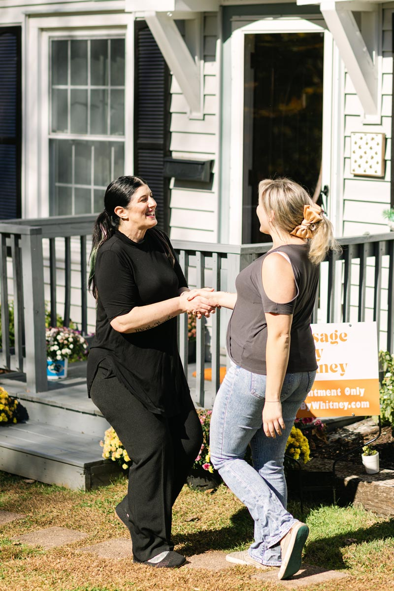 Massage Therapist Whitney Laws greeting a new client outside of her home studio.
