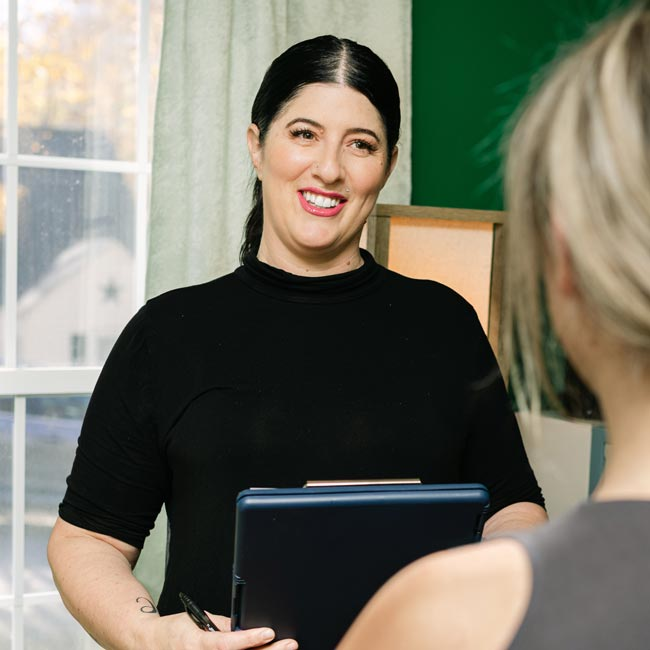 Massage Therapist Whitney Laws reviewing a new client intake form ahead of their session.