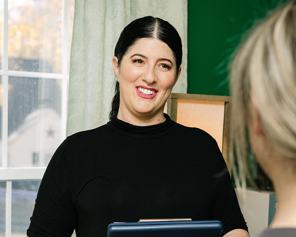 Massage Therapist, Whitney Laws, talking with a client.